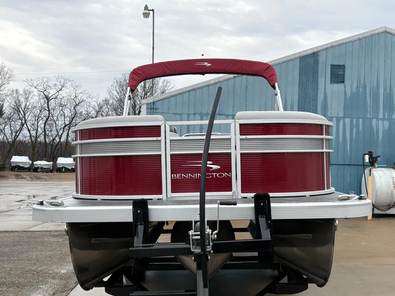 Slide: The Image of 2020 Bennington 22 SLX pontoon boat with red exterior, parked outdoors near a blue building. - 6