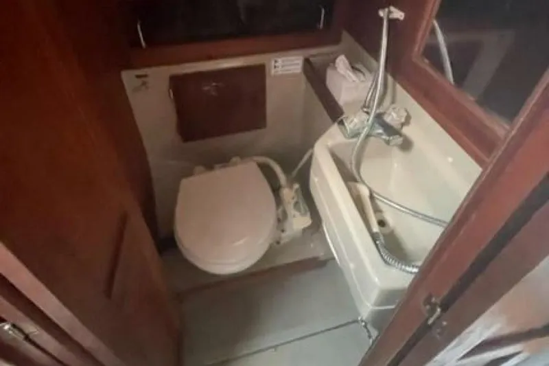 Slide: The Image of Compact bathroom in a 1986 O'Day Masthead Sloop, featuring a toilet and sink. - 21