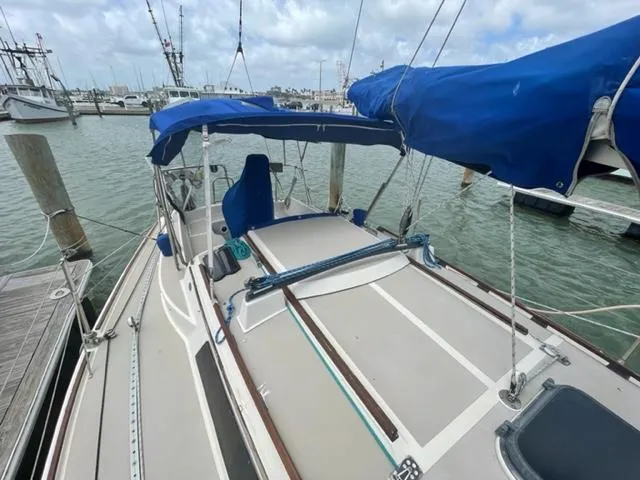 Slide: The Image of 1986 O'Day Masthead Sloop sailboat docked, featuring blue canvas covers and a spacious deck. - 4