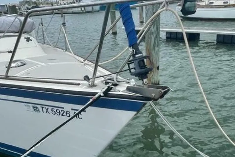 Slide: The Image of 1986 O'Day Masthead Sloop docked, featuring bow details and registration number TX 5926 JC. - 5