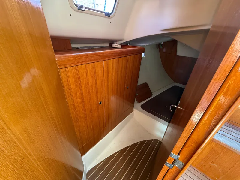 Slide: The Image of 2007 Hunter 33 yacht interior with wooden cabinetry and compact sleeping area. - 12