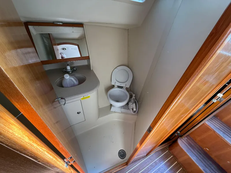 Slide: The Image of Compact bathroom in a 2007 Hunter 33 sailboat with toilet, sink, and mirror. - 14