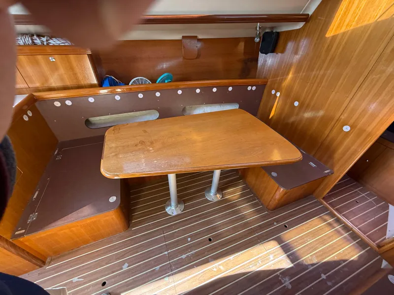 Slide: The Image of Interior of 2007 Hunter 33 sailboat with wooden table and seating area. - 17
