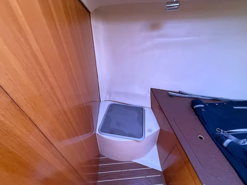 Slide: The Image of Interior of 2007 Hunter 33 sailboat with wooden paneling and compact storage area. - 21