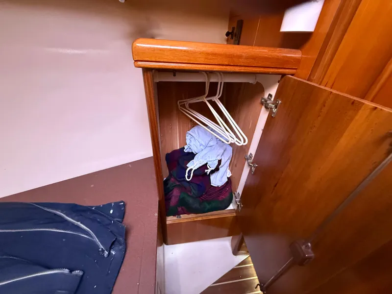 Slide: The Image of Wooden closet with clothes and hangers inside a 2007 Hunter 33 boat. - 23