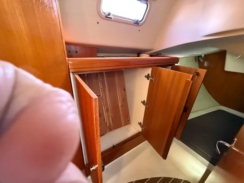 Slide: The Image of Interior of 2007 Hunter 33 sailboat showing wooden cabinetry and storage space. - 25
