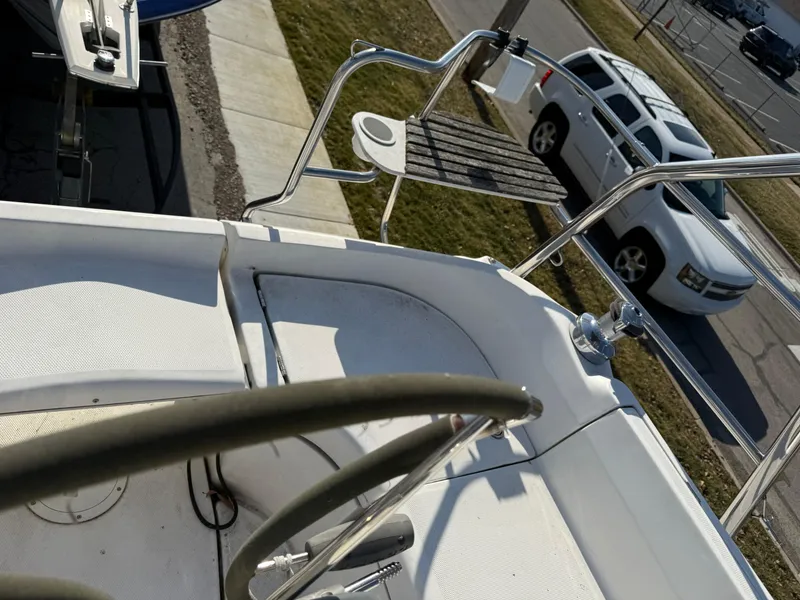 Slide: The Image of 2007 Hunter 33 sailboat cockpit with steering wheel, docked near parked vehicles. - 29