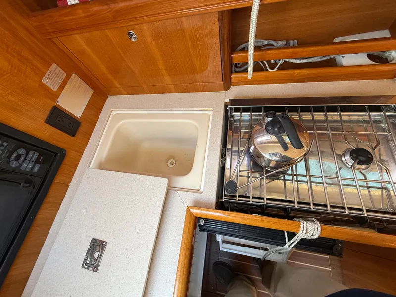 Slide: The Image of Compact kitchen area in a 2007 Hunter 33 sailboat with sink and stove. - 3