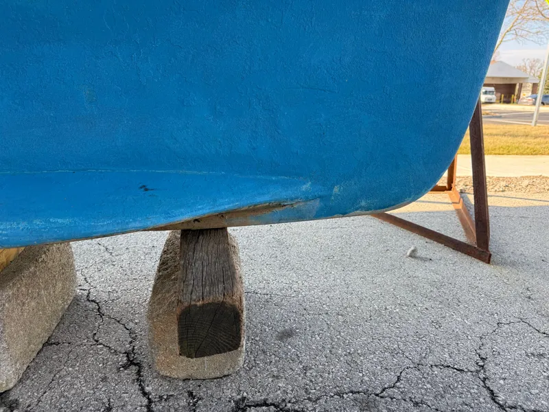 Slide: The Image of 2007 Hunter 33 boat hull on wooden supports, showing minor damage. - 34