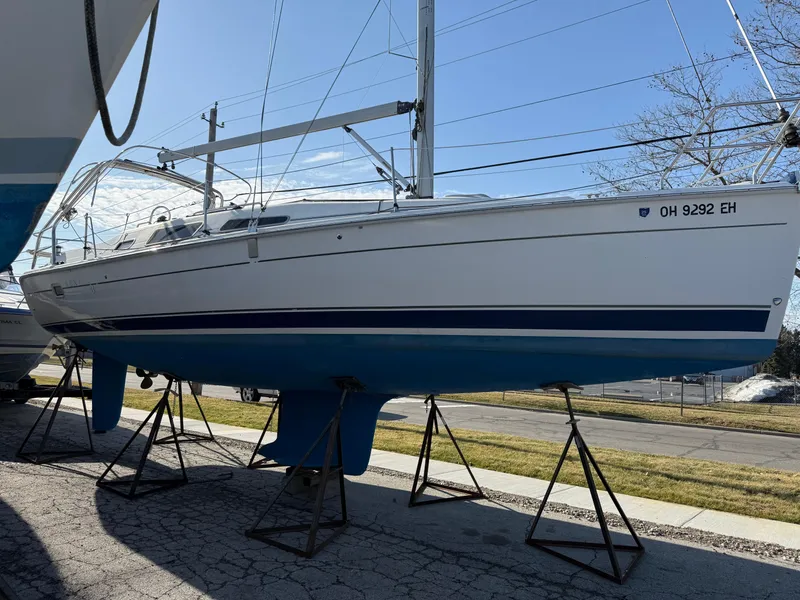 Slide: The Image of 2007 Hunter 33 sailboat on stands, displayed outdoors, with visible registration number. - 36