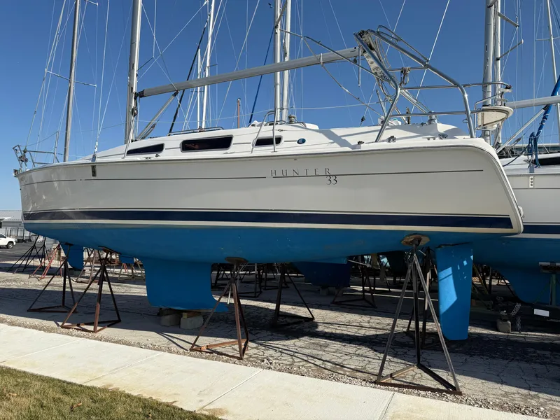 Slide: The Image of 2007 Hunter 33 sailboat on stands, white hull, blue keel, marina setting. - 40
