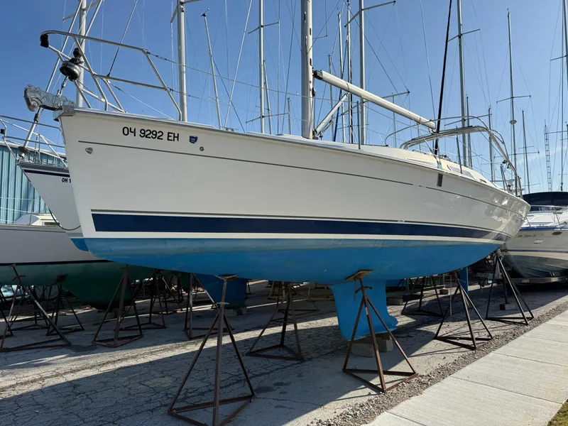 Slide: The Image of 2007 Hunter 33 sailboat on stands in a marina, white hull with blue stripe. - 41