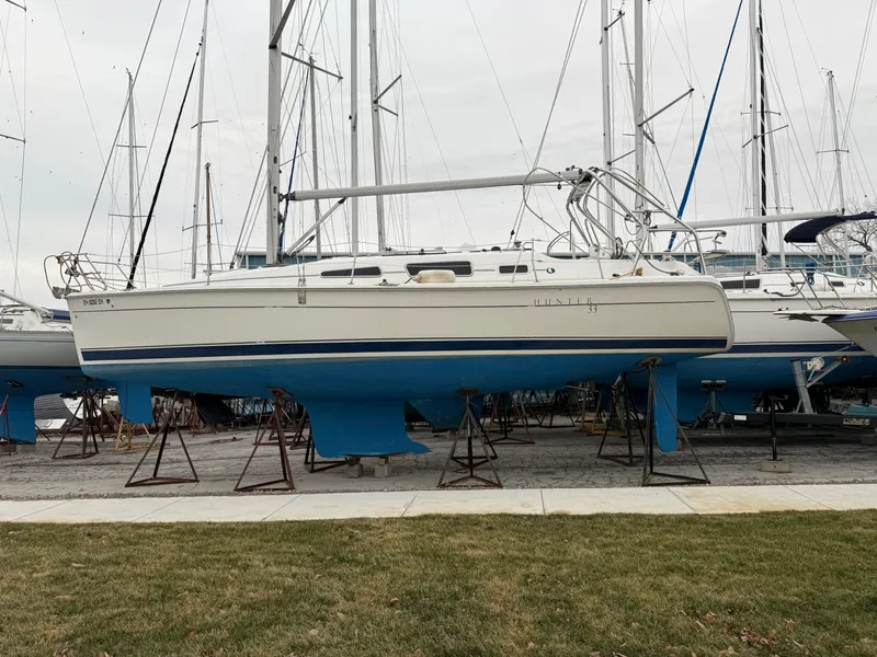 Slide: The Image of 2007 Hunter 33 sailboat on stands, marina background, overcast sky. - 43