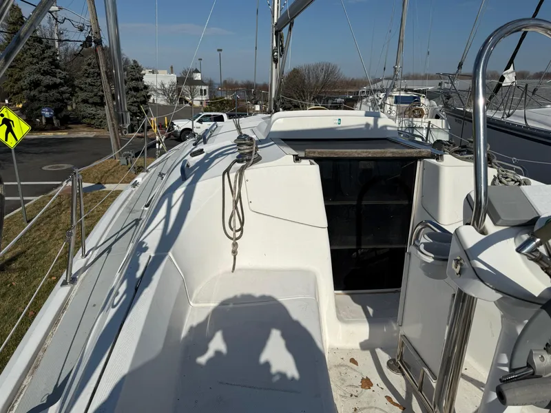 Slide: The Image of 2007 Hunter 33 sailboat deck with rigging and open hatch, docked outdoors. - 47