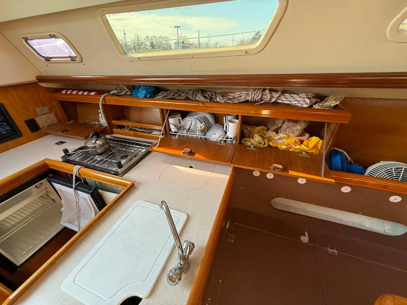 Slide: The Image of Interior of a 2007 Hunter 33 sailboat kitchen with stove, sink, and storage. - 7