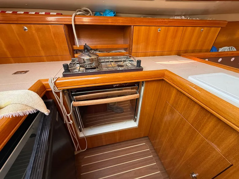 Slide: The Image of Wooden kitchen interior of a 2007 Hunter 33 sailboat with stove and oven. - 9