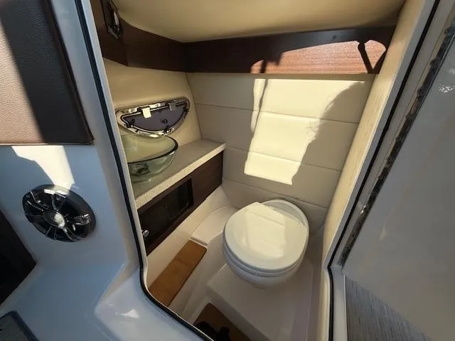 Slide: The Image of 2016 Regal 2800 Bowrider boat interior bathroom with toilet and glass sink. - 16