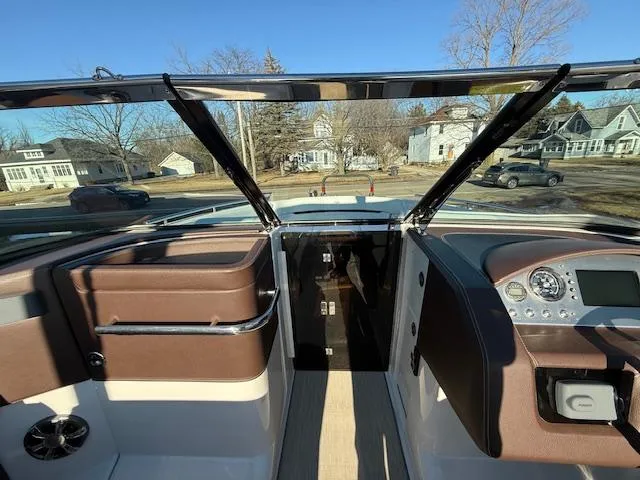 Slide: The Image of 2016 Regal 2800 Bowrider interior with dashboard and seating, parked in residential area. - 17