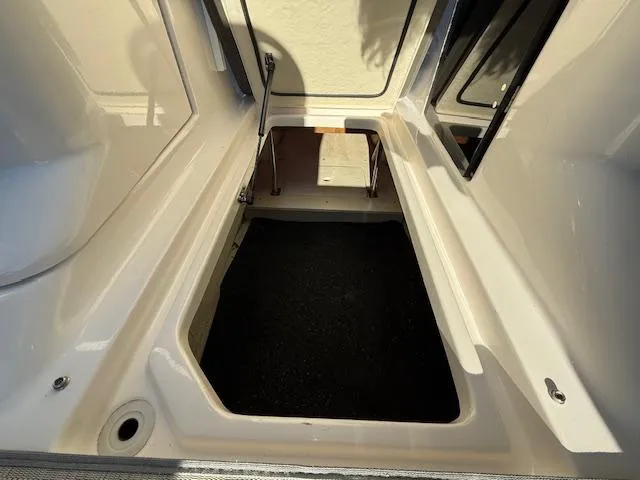 Slide: The Image of 2016 Regal 2800 Bowrider storage compartment, open and empty, with sunlight casting shadows. - 18