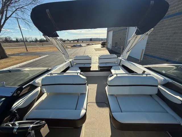 Slide: The Image of 2016 Regal 2800 Bowrider boat with spacious seating and canopy, docked outdoors. - 23