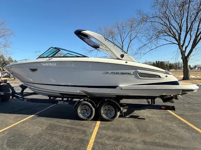 Slide: The Image of 2016 Regal 2800 Bowrider boat on trailer in parking lot, clear sky background. - 3