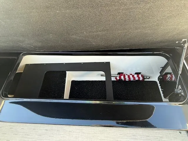 Slide: The Image of Storage compartment in a 2016 Regal 2800 Bowrider boat, featuring black interior lining. - 8