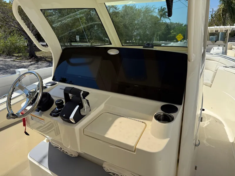 Slide: The Image of 2025 Scout 330 LXF boat dashboard with steering wheel and controls. - 10