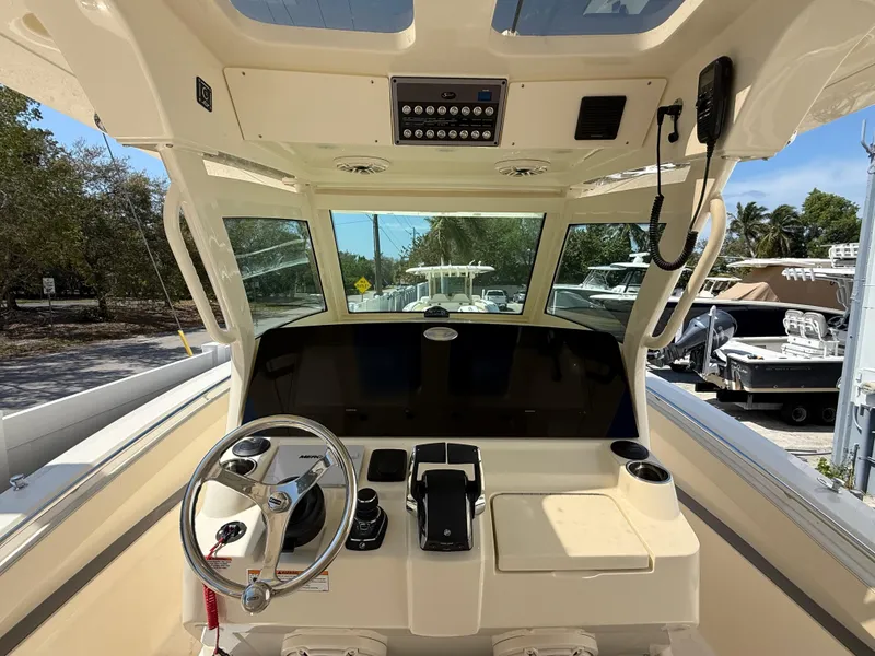 Slide: The Image of 2025 Scout 330 LXF boat cockpit with steering wheel and control panel. - 11