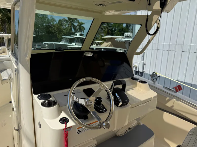 Slide: The Image of 2025 Scout 330 LXF boat cockpit with steering wheel and control panel. - 12