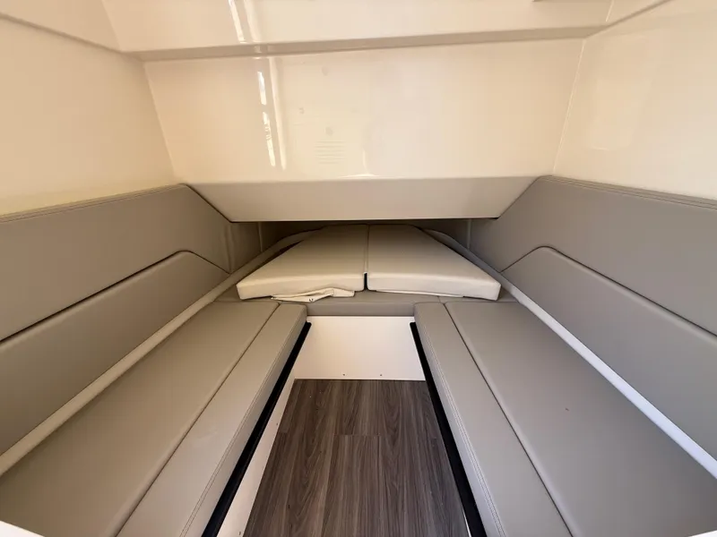 Slide: The Image of 2025 Scout 330 LXF cabin interior with cushioned seating and wood flooring. - 21