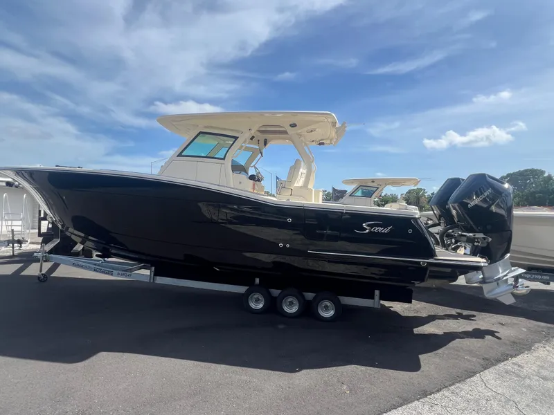 Slide: The Image of 2025 Scout 330 LXF boat with sleek black hull on a trailer. - 3