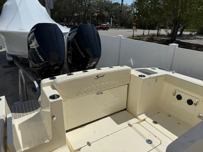 Slide: The Image of 2025 Scout 330 LXF boat with dual outboard engines, parked outdoors. - 5
