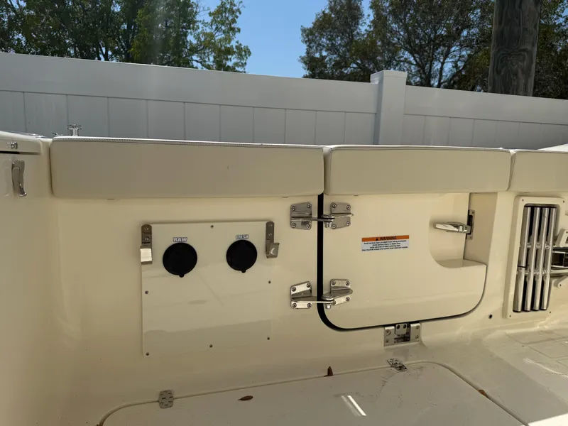 Slide: The Image of 2025 Scout 330 LXF boat interior with utility access panel and fittings. - 7