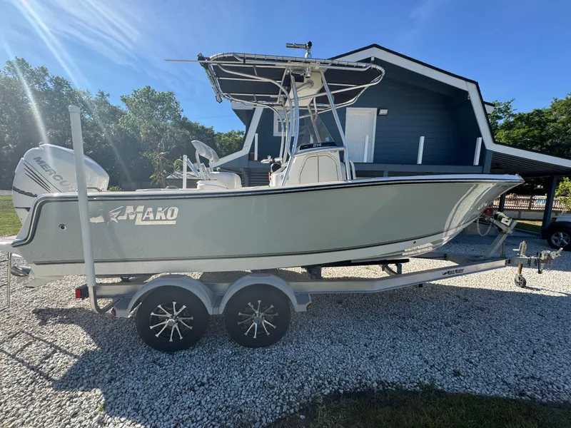 Slide: The Image of 2019 Mako 214C boat on trailer, parked in front of a house, sunny day. - 19