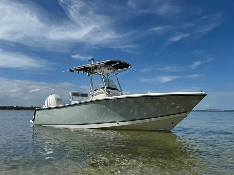 Slide: The Image of 2019 Mako 214C boat on calm water under a clear blue sky. - 2