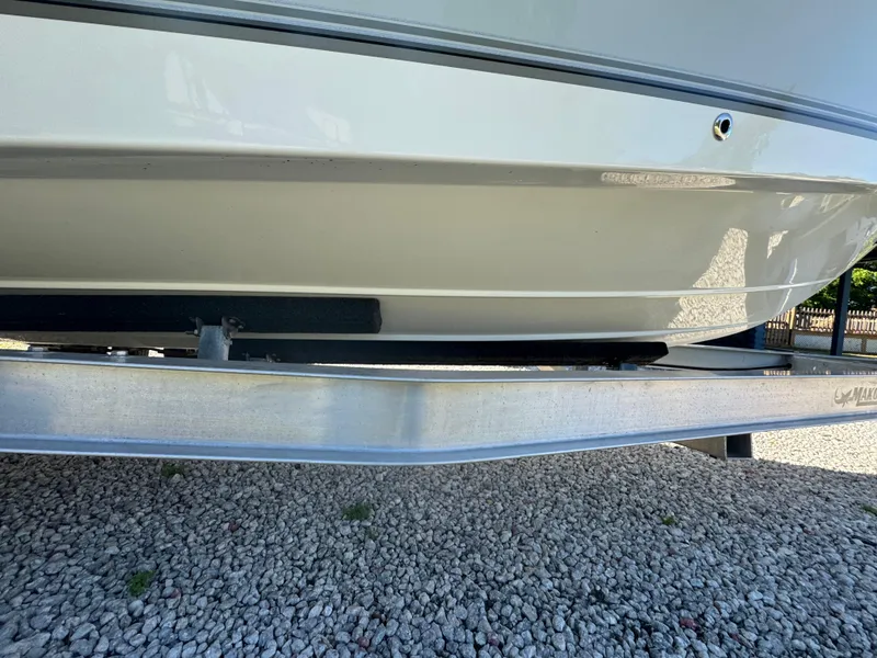 Slide: The Image of 2019 Mako 214C boat hull on trailer, resting on gravel surface. - 21
