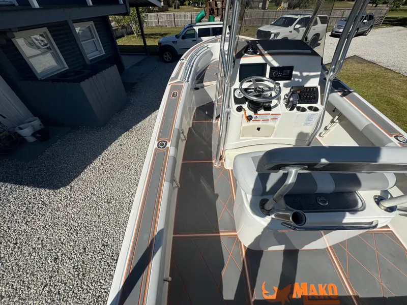 Slide: The Image of 2019 Mako 214C boat with modern console and seating, parked on gravel driveway. - 31