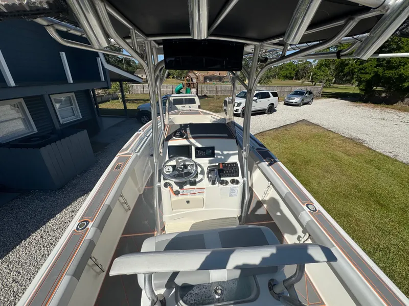 Slide: The Image of 2019 Mako 214C boat with center console, parked outdoors near a house and vehicles. - 32