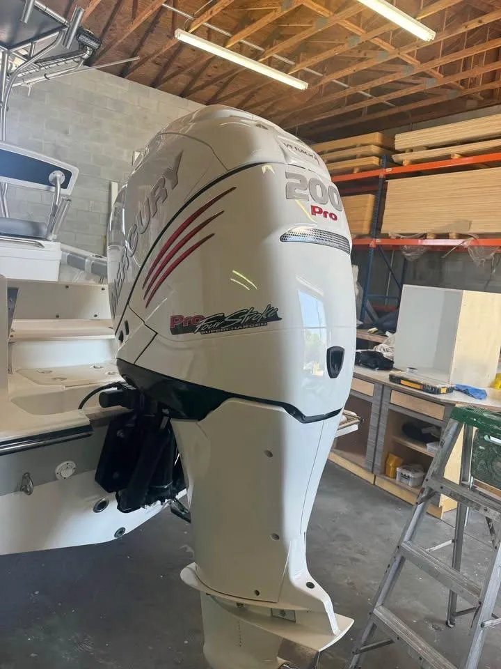 Slide: The Image of 2019 Mako 214C boat with Mercury 200 Pro outboard motor in a garage. - 4