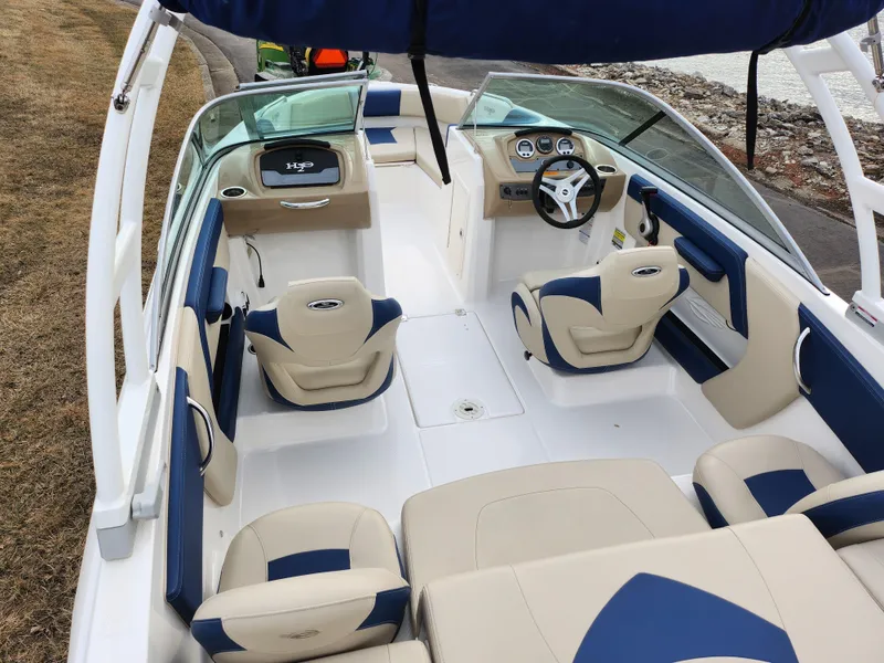 Slide: The Image of 2017 Chaparral 21 H2O Ski & Fish OB boat interior with beige and blue seating. - 10