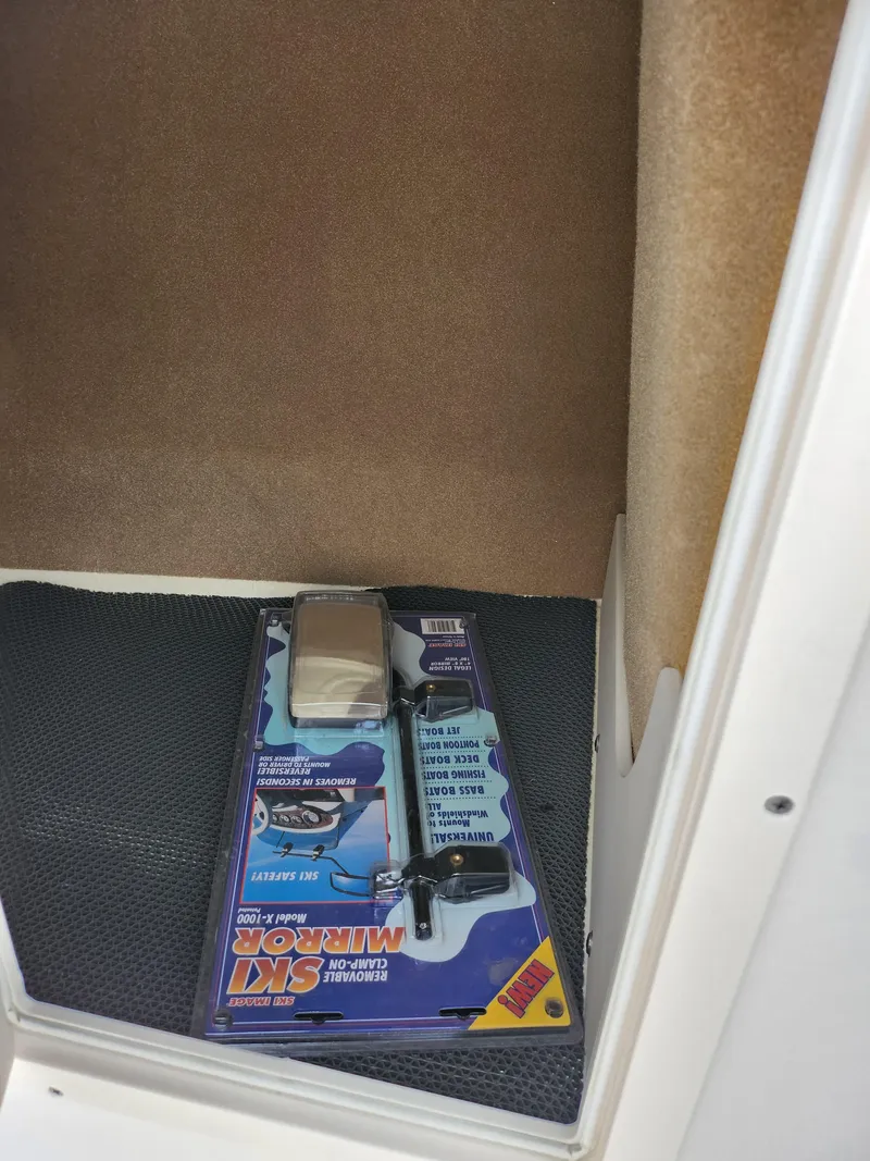 Slide: The Image of 2017 Chaparral 21 H2O Ski & Fish OB storage compartment with a packaged marine accessory. - 18