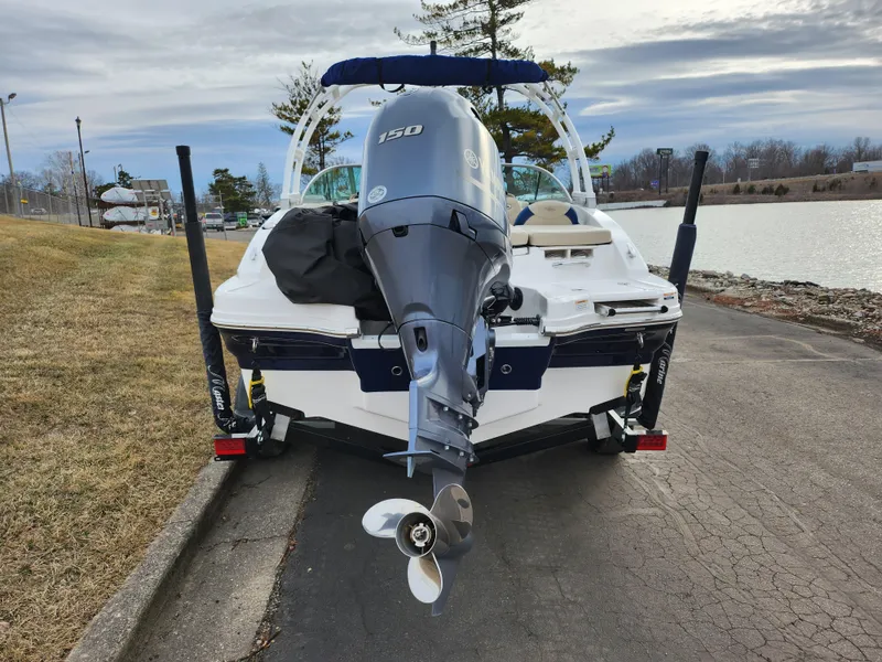 Slide: The Image of 2017 Chaparral 21 H2O Ski & Fish OB boat with outboard motor, parked near a lake. - 2