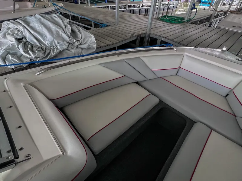 Slide: The Image of 1993 Chaparral 2200 SL boat interior with white seating and red trim, docked at marina. - 27