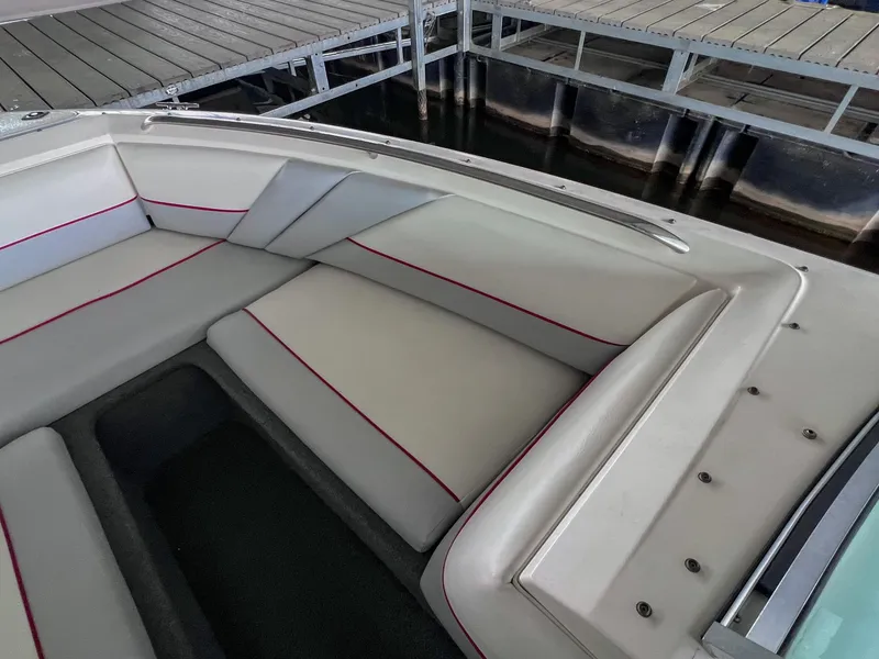 Slide: The Image of 1993 Chaparral 2200 SL boat interior with white and red seating, docked at a marina. - 29