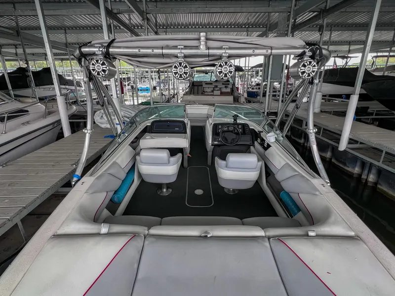 Slide: The Image of 1993 Chaparral 2200 SL boat interior with seating and speakers, docked in a covered marina. - 3
