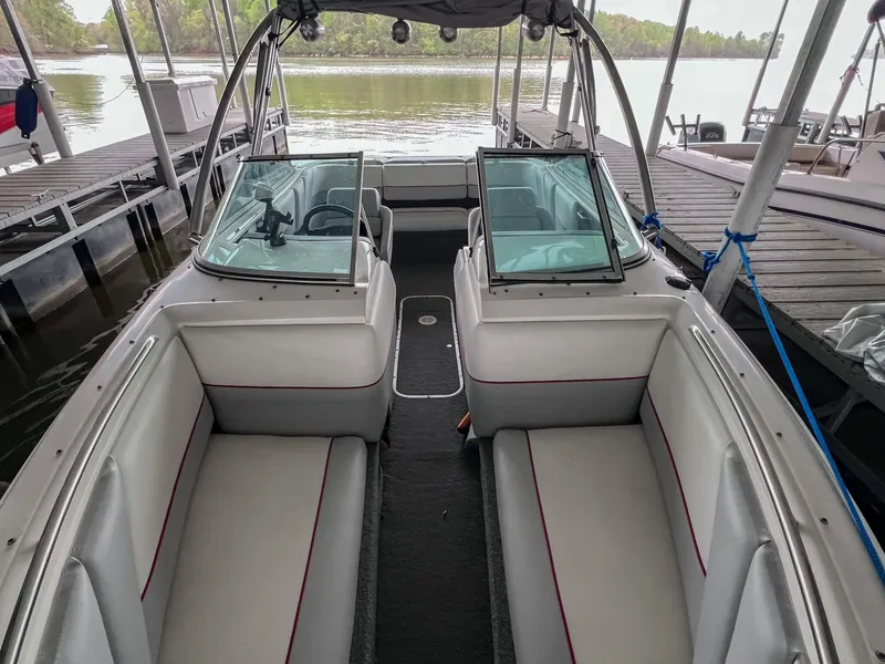 Slide: The Image of Chaparral 2200 SL 1993 boat interior with seating, docked by a lake. - 32