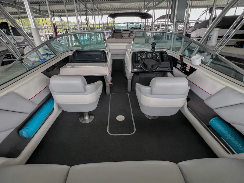 Slide: The Image of 1993 Chaparral 2200 SL boat interior with seating and steering wheel, docked in a marina. - 7