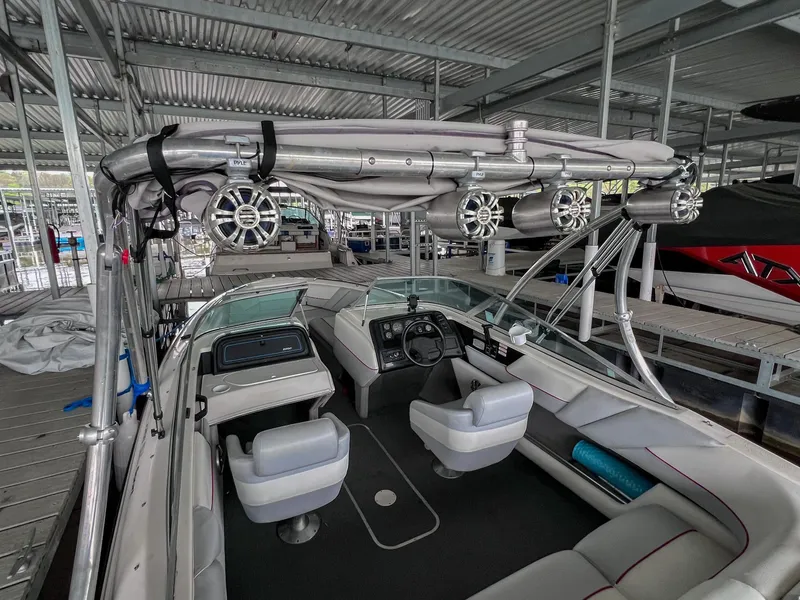 Slide: The Image of 1993 Chaparral 2200 SL boat interior with seating and dashboard, docked in a covered marina. - 8