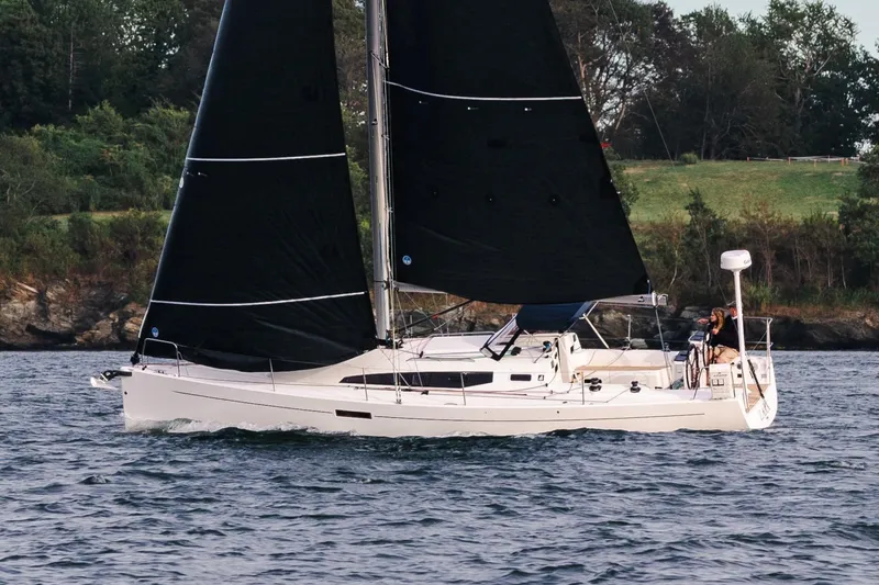 Slide: The Image of 2026 J Boats J/36 sailing on a calm lake with lush green shoreline. - 2