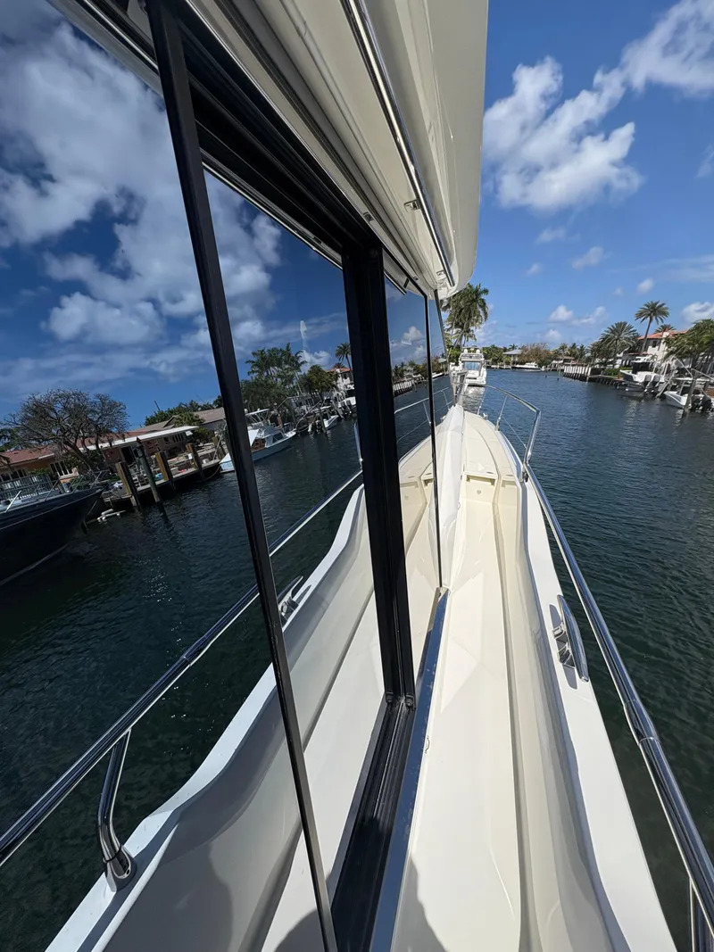 Slide: The Image of 2018 Prestige 680 yacht on a sunny day, docked in a serene marina. - 30